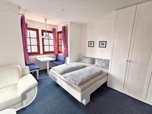 a bedroom with a bed and a chair and a desk at BodenSEE Apartment Kressbronn Fischerdorf SEE 4 in Kressbronn am Bodensee