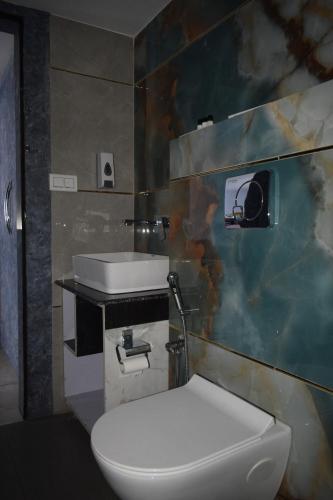 a bathroom with a white toilet and a sink at Country Ambience Hotel in Haldwāni