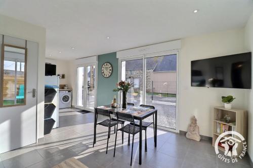 une salle à manger avec une table et une horloge au mur dans l'établissement Manoky, à Cherrueix