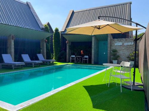 a swimming pool with a table and an umbrella at Sawasdee​ Buriram​ Resort in Buriram