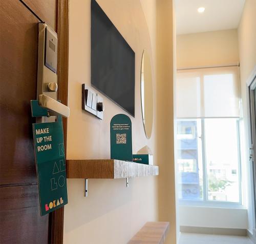 a living room with a flat screen tv on a wall at LOKAL Flagship x Karachi - DHA in Karachi