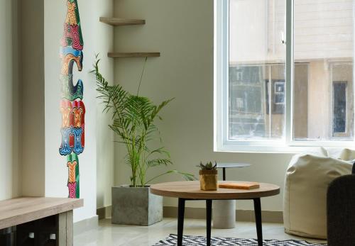a living room with a table and a plant at LOKAL Flagship x Karachi - DHA in Karachi