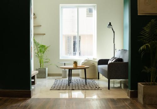 a living room with a table and a chair at LOKAL Flagship x Karachi - DHA in Karachi
