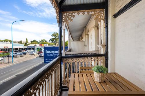 a wooden bench sitting on a balcony with a sign at Lume Outlook - Dedicated Workspace, Wi-FI, Parking in Unley