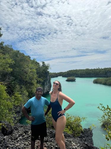 a man and a woman standing next to a body of water at Amaro Homestay in Nuhu Tawun