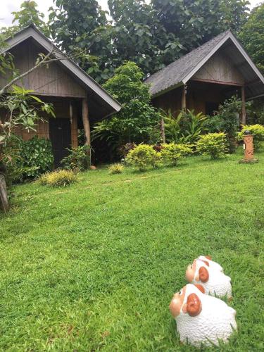 two rubber ducks sitting on the grass in a yard at สวนบนคอทเทจ เชียงดาว in Ban Tham