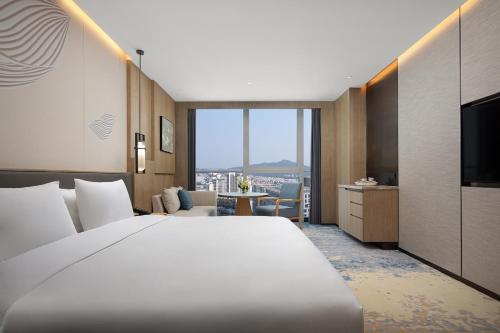 a hotel room with a large bed and a television at Wyndham Hotel Guangzhou Huangbian Metro Branch - Free shuttle bus to Canton Fair in Guangzhou