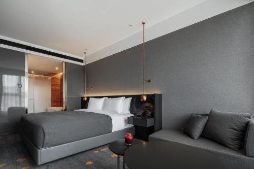 a hotel room with a bed and a couch at Wanda Yi, Xi'an The Linow in Xi'an
