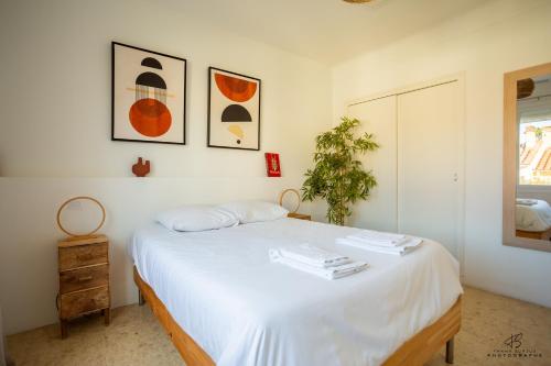 a bedroom with a bed with white sheets and a plant at Zen Paradise - Near the city center - Garden in Perpignan