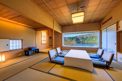 a large room with a table and chairs and a large window at Ryuguden in Hakone