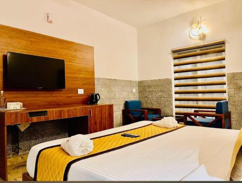 a hotel room with a bed and a flat screen tv at Skylark Holidays Premium in Chinnakanal