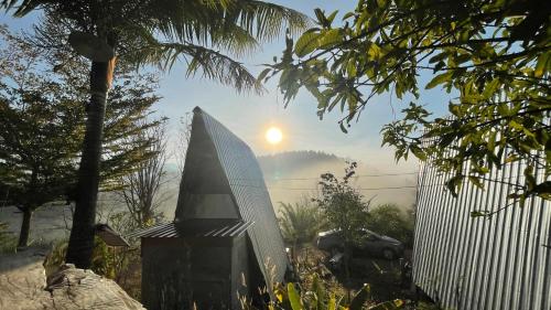 a view of the sun rising behind a fence at Monsonkeang Camping view ม่อนสันเกี๋ยง in Mae Chaem