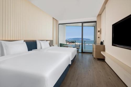 a hotel room with two beds and a flat screen tv at C&D Hotel Dongshan Zhangzhou in Tongling