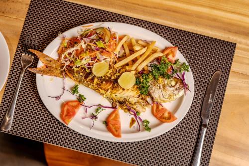 a plate of fish and french fries on a table at The Mansion Koggala in Koggala