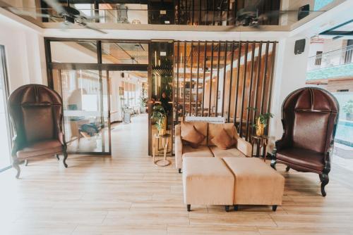 a living room with a couch and two chairs at SureStay Plus Hotel by Best Western AC LUXE Angeles City in Angeles