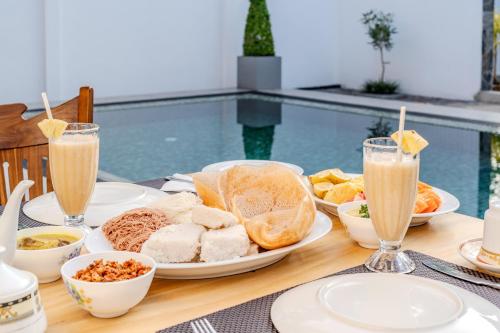 a table topped with plates of food and drinks at The Mansion Koggala in Koggala