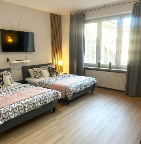 a bedroom with two beds and a flat screen tv at Exclusive Apartments Smolna in Warsaw