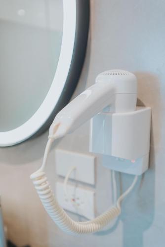 a white phone is plugged into a mirror at SureStay Plus Hotel by Best Western AC LUXE Angeles City in Angeles