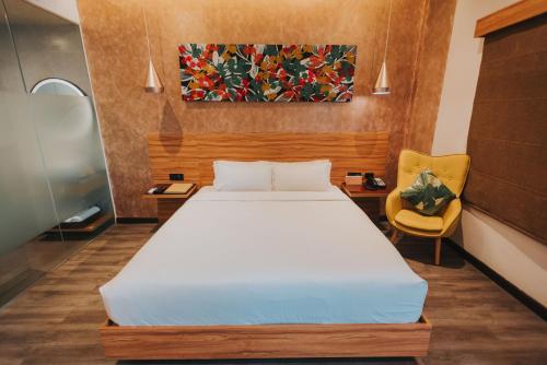 a bedroom with a bed and a painting on the wall at SureStay Plus Hotel by Best Western AC LUXE Angeles City in Angeles