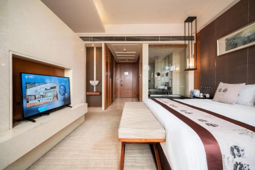a bedroom with a large bed and a flat screen tv at Chengdu Joyhub Air Hotel in Chengdu