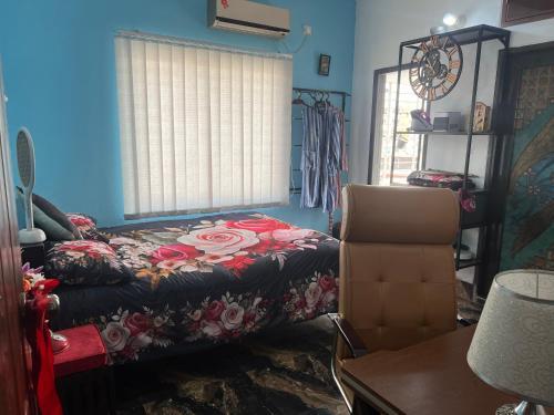 a bedroom with a bed and a chair in it at Sweet & Cozy Home - Staying is Worthy! in Dhaka