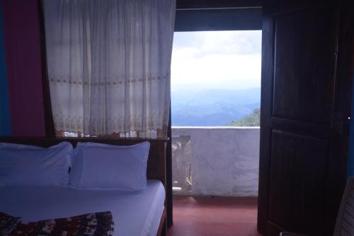 a bedroom with a bed and a window with a view at Choice hotels in Haputale