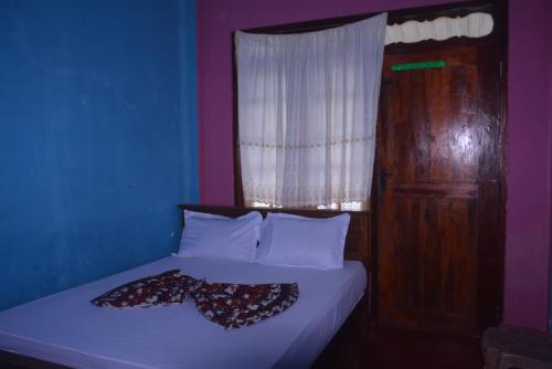 a bed in a blue room with a window at Choice hotels in Haputale