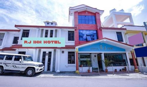 a white suv parked in front of a building at RJ Inn in Kodaikānāl
