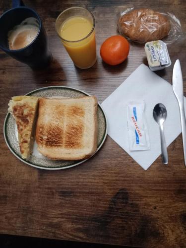 a table with a plate of toast and a glass of orange juice at ALBERGUE CASA BAZTAN in Uterga