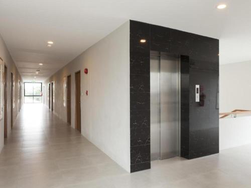 a hallway with a elevator in a building at Esy Hotel in Lamphun