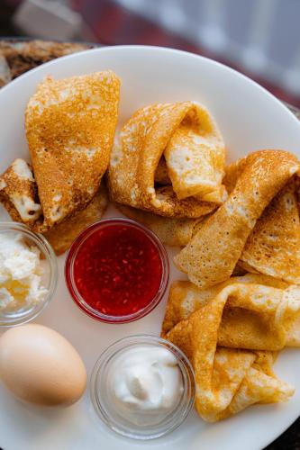 a plate of food with eggs and bread and dips at Bishkek Centrum Hotel in Bishkek