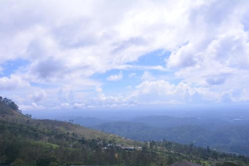 a view of the ocean from a mountain with clouds at Choice hotels in Haputale