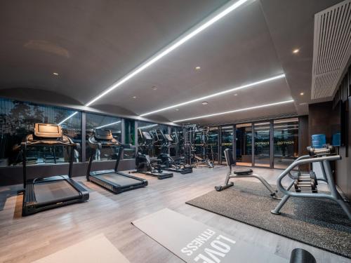 a gym with treadmills and elliptical machines at 西安钟楼枫渡酒店永兴坊地铁站店 in Xi'an