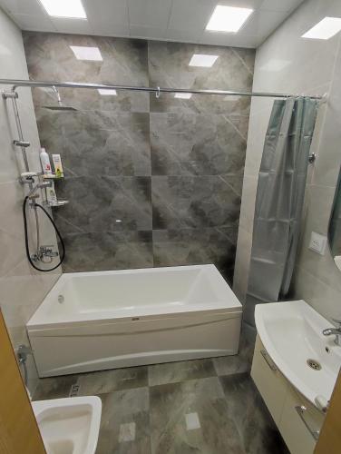 a bathroom with a shower and a tub and a sink at Апартаменты у моря - в "Green City RESORT" in Baku