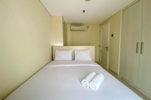 ein kleines Zimmer mit einem Bett mit zwei Handtüchern darauf in der Unterkunft New and Spacious 3BR at Marquis de Lafayette Apartment By Travelio in Semarang