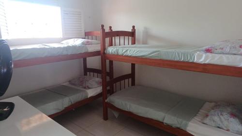 three bunk beds in a room with a window at Recanto do Ze Bonito in Conde