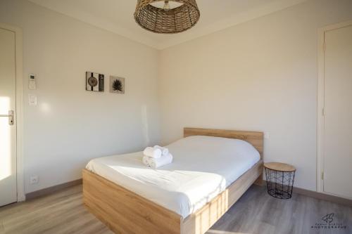 Cette petite chambre comprend un lit avec des draps blancs. dans l'établissement L'oranger Proche centre ville WIFINETFLIX, à Perpignan