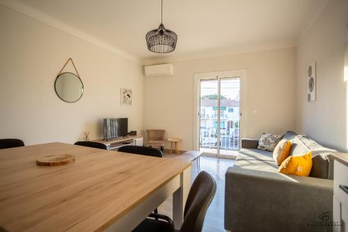 un salon avec une table et un canapé dans l'établissement L'oranger Proche centre ville WIFINETFLIX, à Perpignan