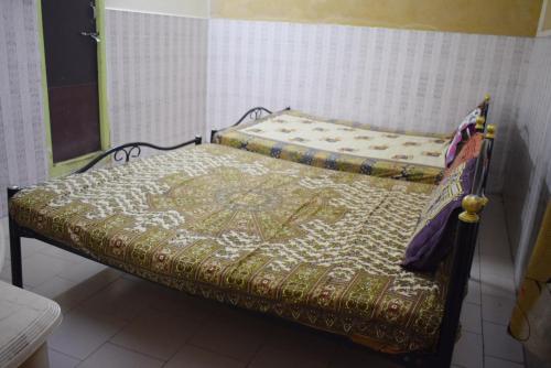 a bed with a quilt on it in a room at S M Residency in Mayiladuthurai