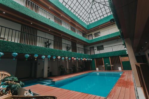 a swimming pool in a building with a skylight at SureStay Studio by Best Western Clarkview Angeles City in Angeles