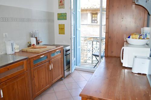 une cuisine avec des placards en bois et une grande fenêtre dans l'établissement Lamour Pezenas hideaway, à Pézenas