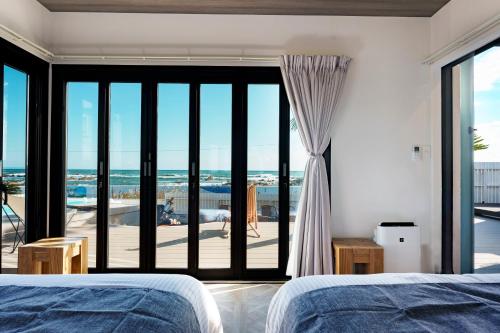 a bedroom with a view of the beach at UMInoTERRACE in Minamiboso