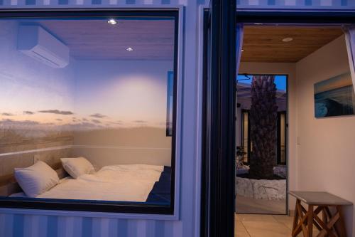 a reflection of a bed in a window at UMInoTERRACE in Minamiboso
