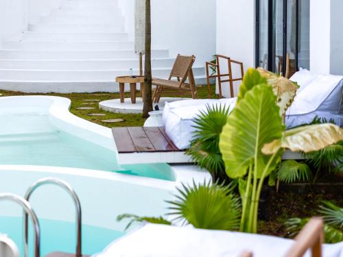 a patio with a hot tub next to a house at Ôkeanos Boutique Hotel - Uluwatu Ungasan in Uluwatu