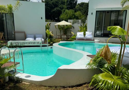 a swimming pool next to a house with a pool at Ôkeanos Boutique Hotel - Uluwatu Ungasan in Uluwatu