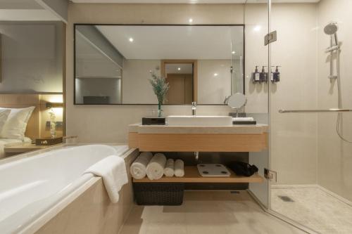 a bathroom with a tub and a sink and a mirror at Shanghai Baixia Pagoda Hotel in Shanghai