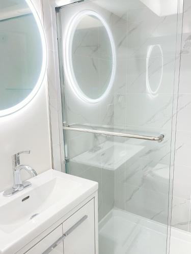 a bathroom with a shower and a sink and a mirror at Beautiful place with Kitchen, Washing Machine, Internet near UBC, beach and DT in Vancouver