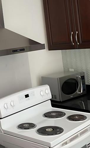 a microwave sitting on top of a stove in a kitchen at Beautiful place with Kitchen, Washing Machine, Internet near UBC, beach and DT in Vancouver