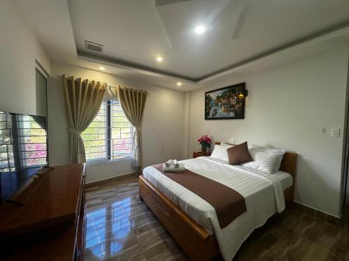a bedroom with a large bed and two windows at Holiday Hotel in Phu Quoc