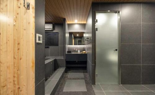 a bathroom with a walk in shower and a sink at Aank Ryokan Hotel Jeonju in Jeonju